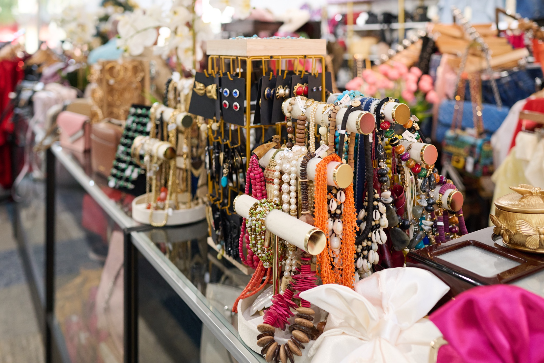 A designer handbag styled with sunglasses, a silk scarf and gold jewelry